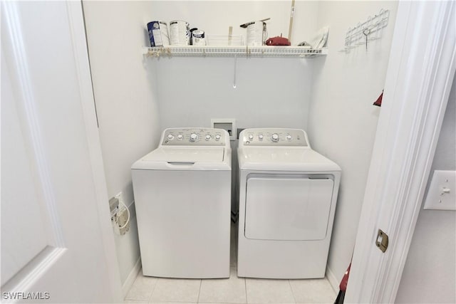 washroom featuring light tile patterned flooring and washer and clothes dryer