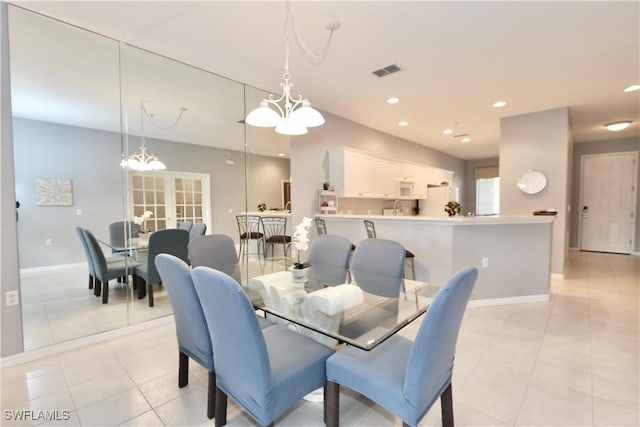 dining area featuring light tile patterned floors and an inviting chandelier