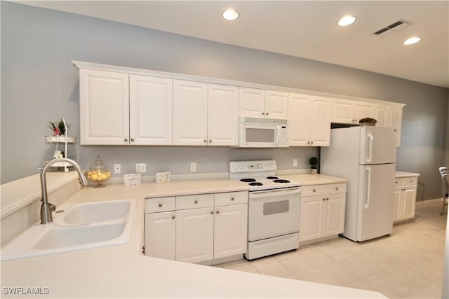 kitchen featuring light tile patterned floors, sink, white cabinets, and white appliances