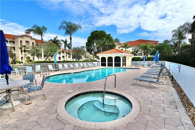 view of pool with a patio area and a hot tub