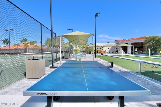 exterior space featuring a tennis court and fence