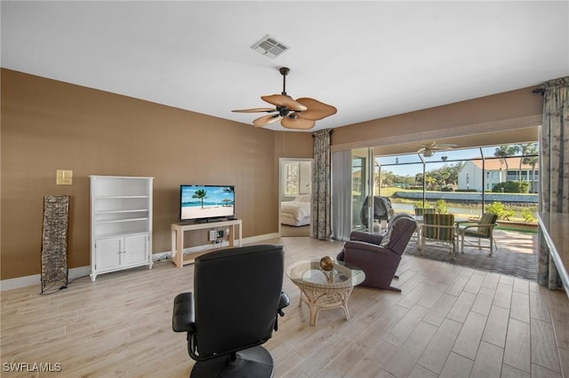 living room with ceiling fan and light hardwood / wood-style floors