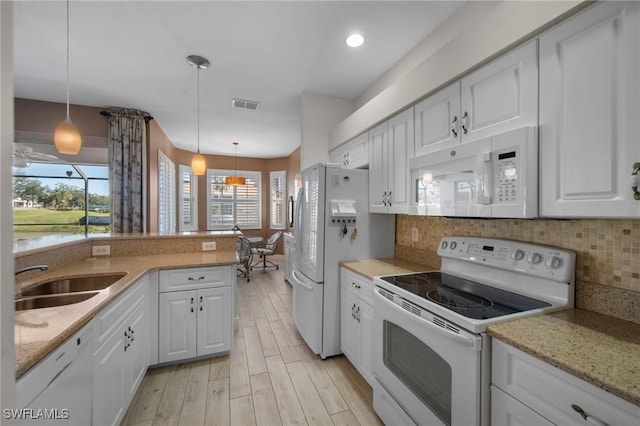 kitchen featuring pendant lighting, white appliances, and white cabinetry