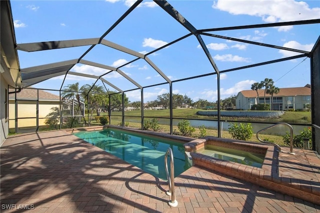 view of pool featuring an in ground hot tub, a water view, glass enclosure, and a patio area