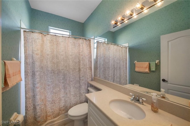 bathroom featuring vanity, curtained shower, and toilet