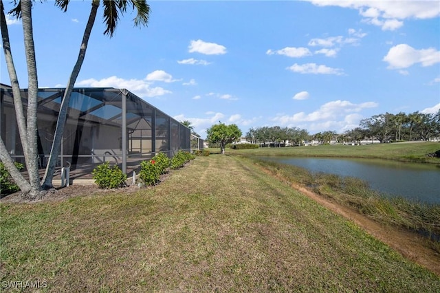 view of yard with glass enclosure and a water view