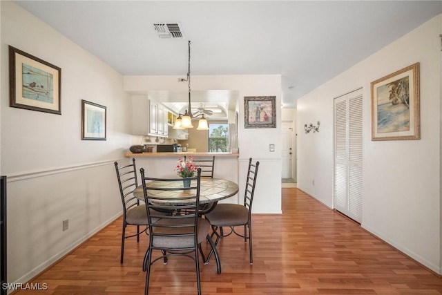 dining area featuring an inviting chandelier and light wood-type flooring