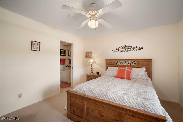 carpeted bedroom with ensuite bath and ceiling fan