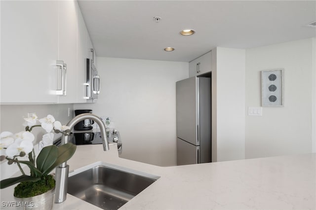 kitchen featuring white cabinets, sink, and appliances with stainless steel finishes