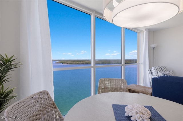 dining room featuring expansive windows and a water view