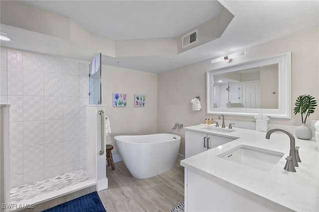 bathroom featuring vanity, wood-type flooring, and shower with separate bathtub