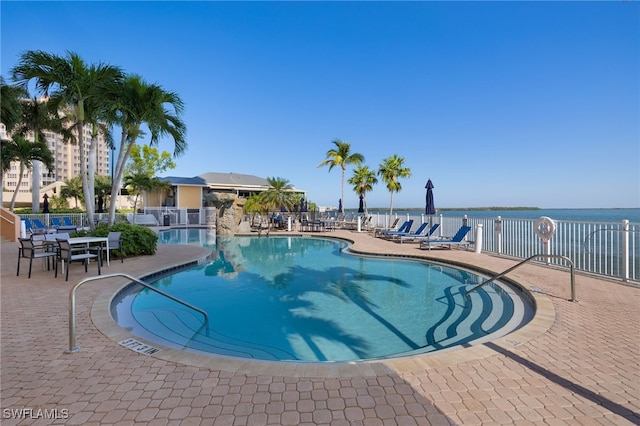 view of pool featuring a patio and a water view