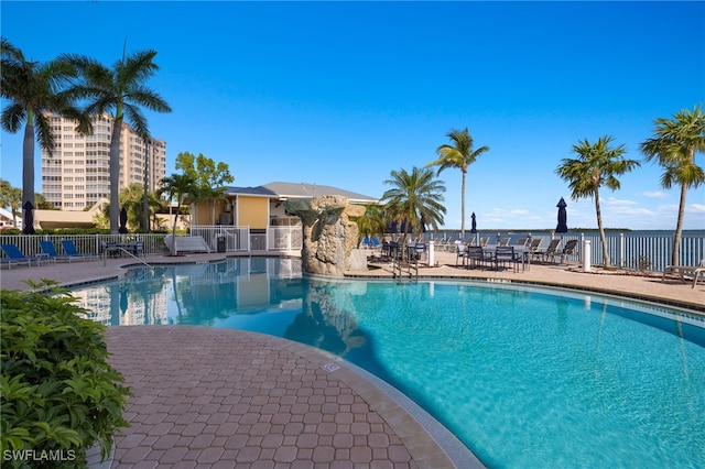 view of swimming pool with a water view and a patio area