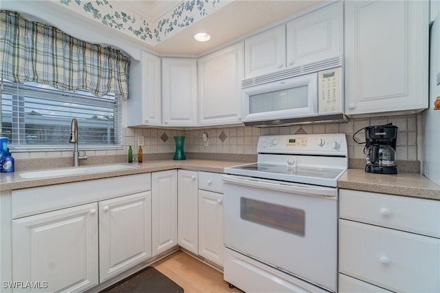 806 SE 46th St Unit 1E, Cape Coral, FL 33904 - kitchen featuring white cabinetry, sink, light hardwood / wood-style flooring, backsplash, and white appliances