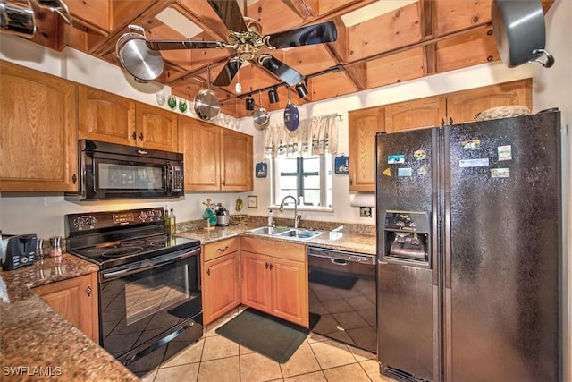 kitchen with black appliances, sink, ceiling fan, dark stone countertops, and light tile patterned floors