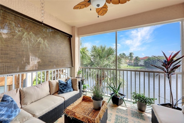 sunroom / solarium with ceiling fan and a water view