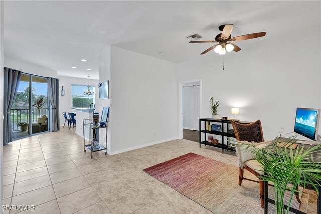 tiled living room featuring ceiling fan with notable chandelier