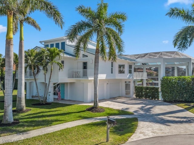 view of front of house with a garage, a balcony, and a front yard