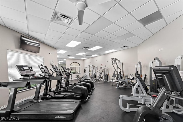 exercise room with baseboards, visible vents, and a drop ceiling