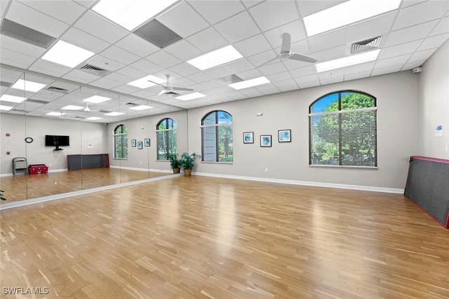 exercise area featuring a wealth of natural light, ceiling fan, visible vents, and wood finished floors