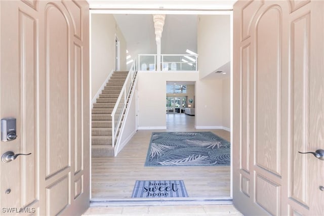 entryway featuring a high ceiling and light hardwood / wood-style floors