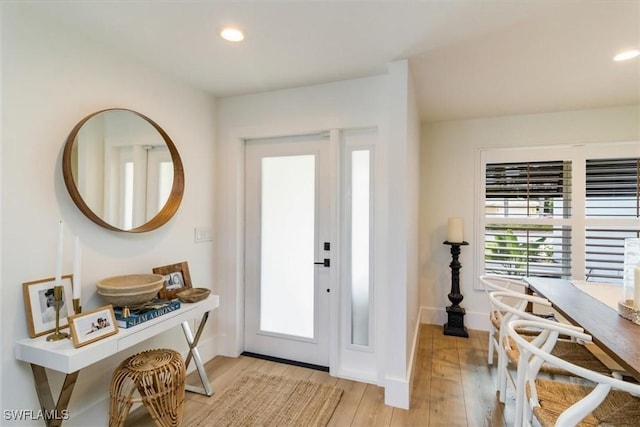 foyer entrance with light wood-style flooring, baseboards, and recessed lighting