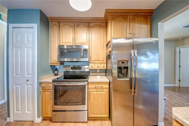 kitchen featuring stainless steel appliances and light hardwood / wood-style floors