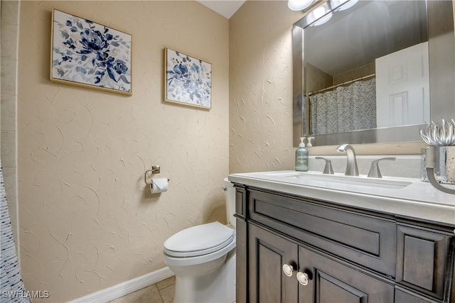 bathroom featuring tile patterned floors, vanity, and toilet