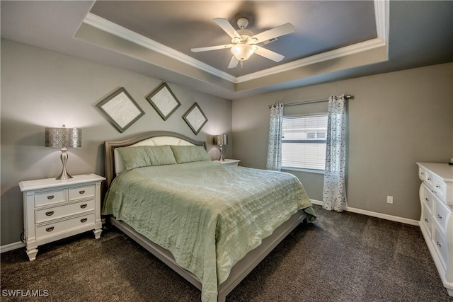 bedroom with ceiling fan, dark carpet, ornamental molding, and a tray ceiling