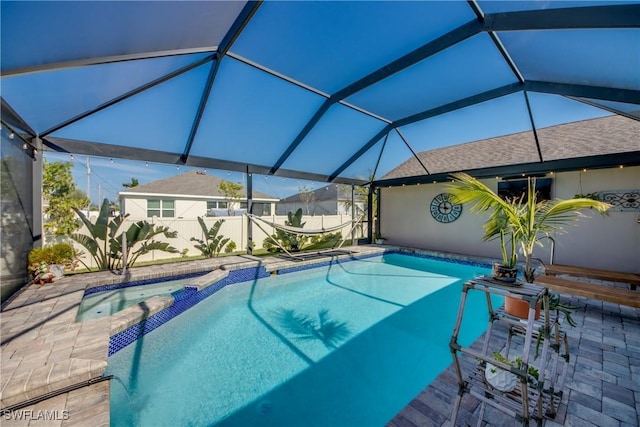 view of swimming pool with a patio area, an in ground hot tub, and glass enclosure