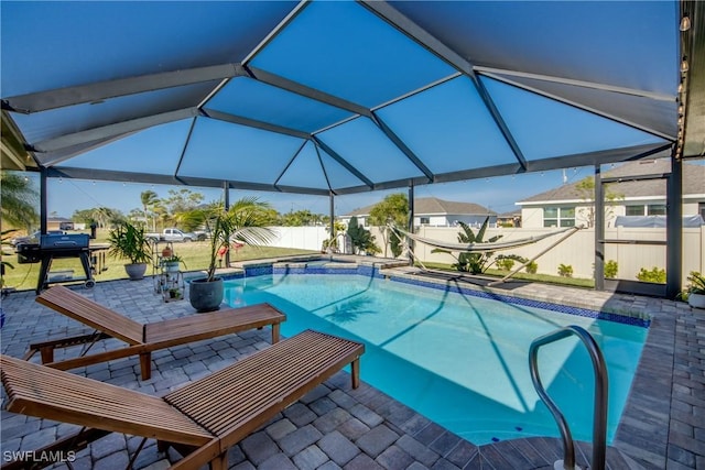 view of swimming pool featuring a patio area, glass enclosure, and grilling area