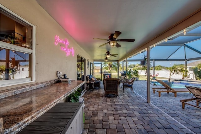 view of patio / terrace with ceiling fan and glass enclosure