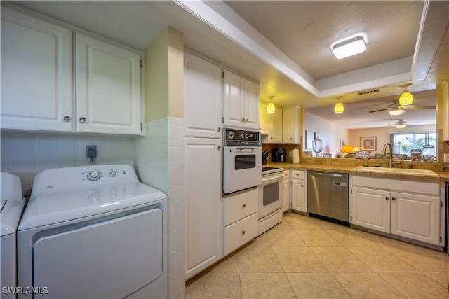 kitchen featuring white cabinetry, sink, washer / clothes dryer, white appliances, and light tile patterned floors