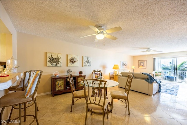 tiled dining space with ceiling fan and a textured ceiling