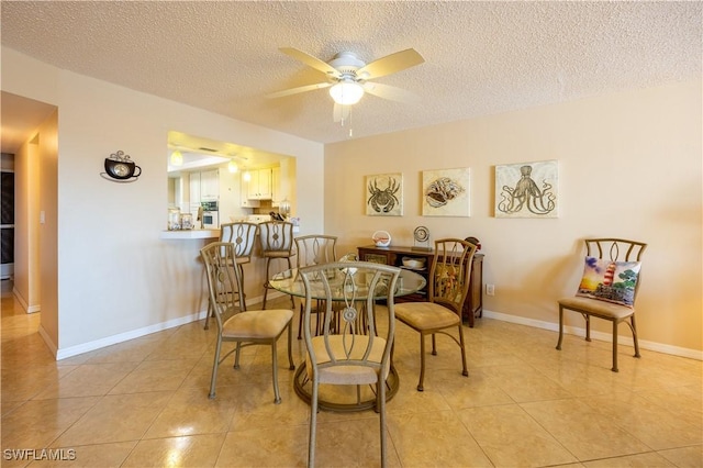 dining room with ceiling fan, light tile patterned floors, and a textured ceiling