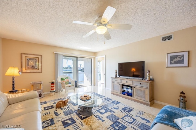 living room with ceiling fan and a textured ceiling