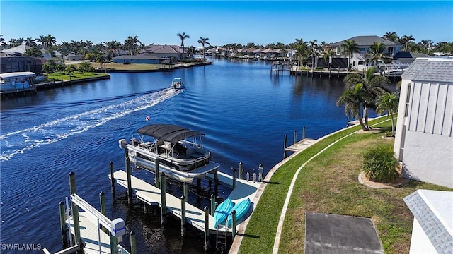 view of dock with a yard and a water view