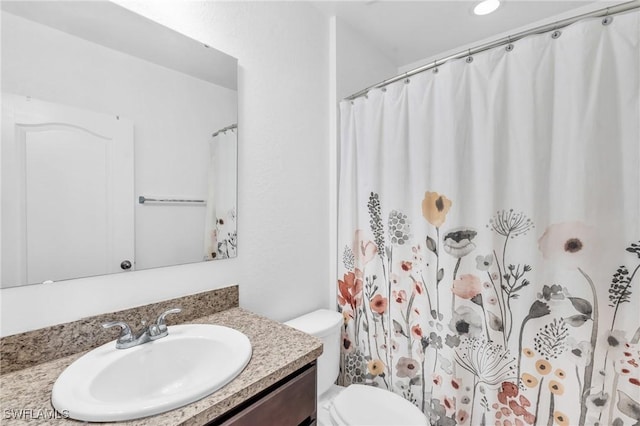 bathroom featuring a shower with curtain, vanity, and toilet