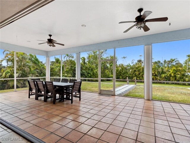 unfurnished sunroom featuring ceiling fan