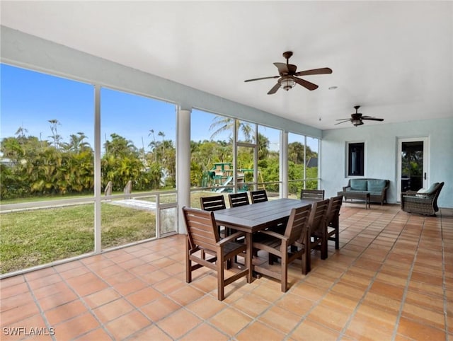 sunroom / solarium featuring ceiling fan