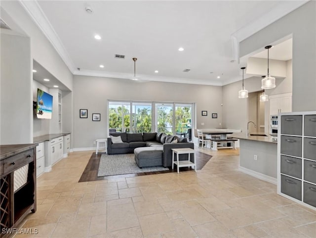 living room with crown molding and sink