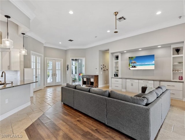 living room with french doors, sink, and ornamental molding