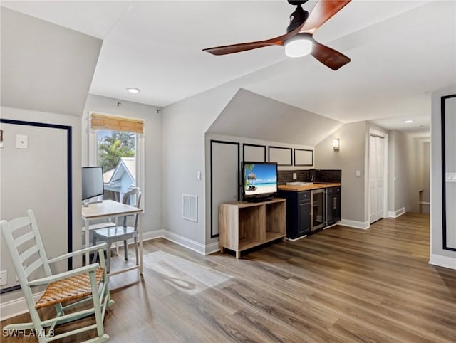 office area featuring vaulted ceiling, ceiling fan, and wood-type flooring