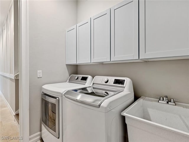 clothes washing area featuring cabinets, sink, washer and clothes dryer, and light tile patterned flooring