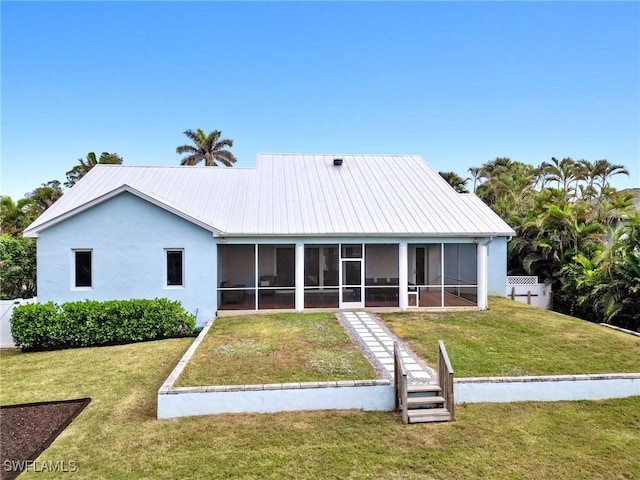 rear view of property with a yard and a sunroom