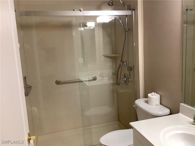 bathroom featuring vanity, toilet, and walk in shower