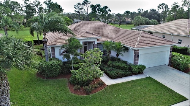 mediterranean / spanish-style home featuring a garage and a front lawn