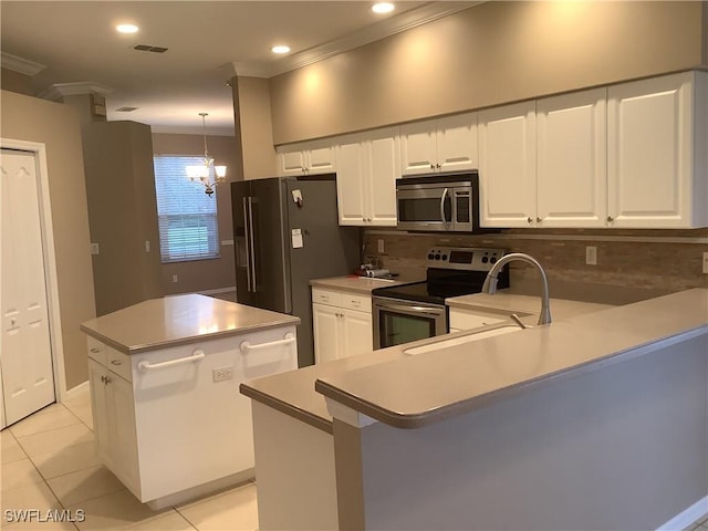 kitchen featuring appliances with stainless steel finishes, a kitchen island, a notable chandelier, white cabinetry, and light tile patterned flooring