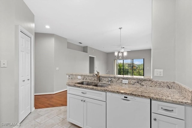 kitchen with sink, light tile patterned floors, light stone counters, white dishwasher, and white cabinets