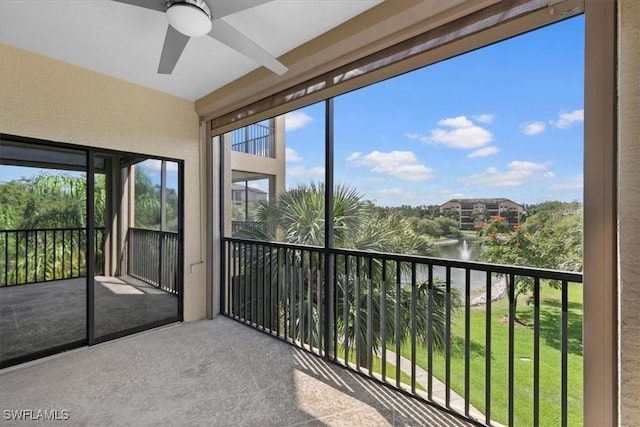 unfurnished sunroom featuring a water view and ceiling fan